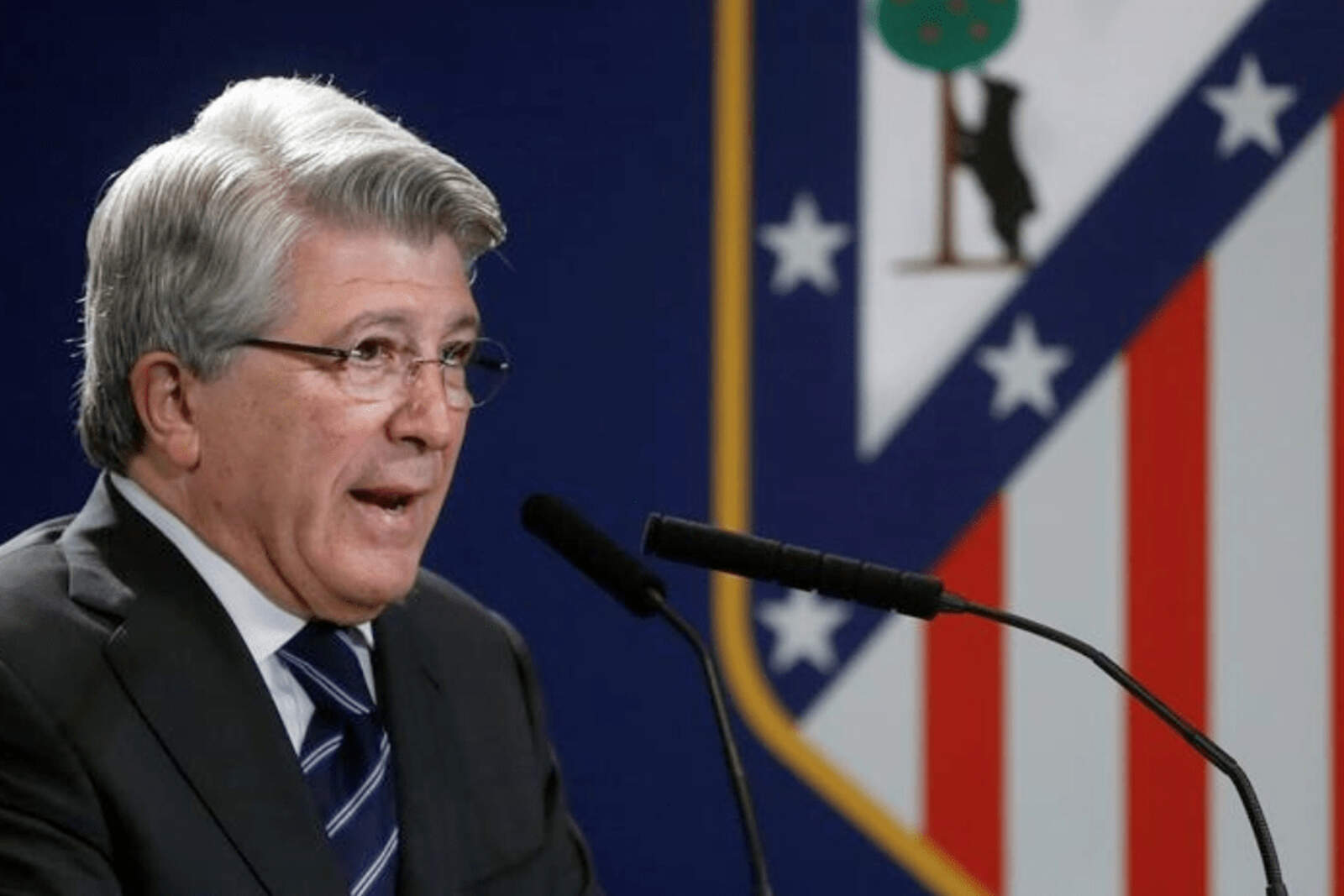 Enrique Cerezo con el escudo del Atleti de fondo