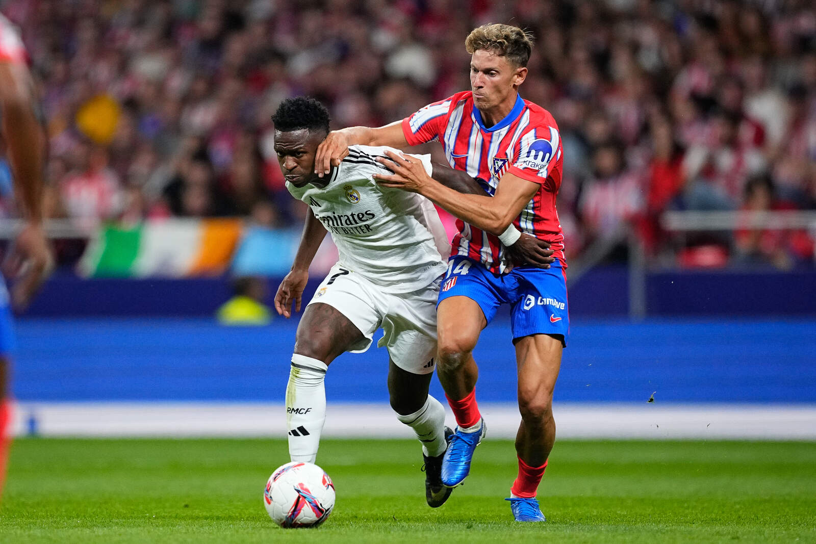 Marcos Llorente y Vinicius peleando por un balón